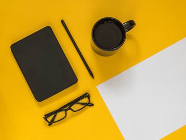 Metin için boş alan sarı zemin üzerine düz yatıyordu siyah iş amaçlı aksesuarları. Üstten görünüm. Kopya alanı.