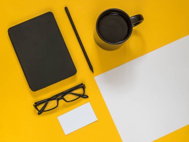 Metin için boş alan sarı zemin üzerine düz yatıyordu siyah iş amaçlı aksesuarları. Üstten görünüm. Kopya alanı.