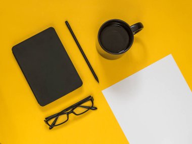 Metin için boş alan sarı zemin üzerine düz yatıyordu siyah iş amaçlı aksesuarları. Üstten görünüm. Kopya alanı.