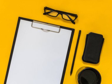 Metin için boş alan sarı zemin üzerine düz yatıyordu siyah iş amaçlı aksesuarları. Üstten görünüm. Kopya alanı.