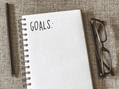 Üstten görünüm defter, kalem, gri kumaş üzerine gözlük ile listesi gol. Yat, alanı Kopyala