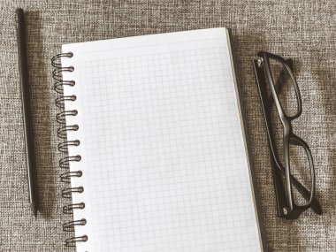 Üstten görünüm defter, kalem, gri kumaş üzerine gözlük ile listesi gol. Yat, alanı Kopyala