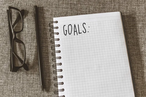 Üstten görünüm defter, kalem, gri kumaş üzerine gözlük ile listesi gol. Yat, alanı Kopyala