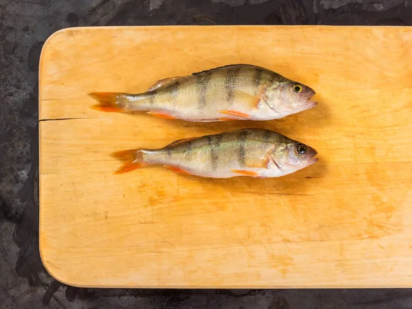 Fresh fish. Fresh river fish perch. On a yellow wooden background. Top view