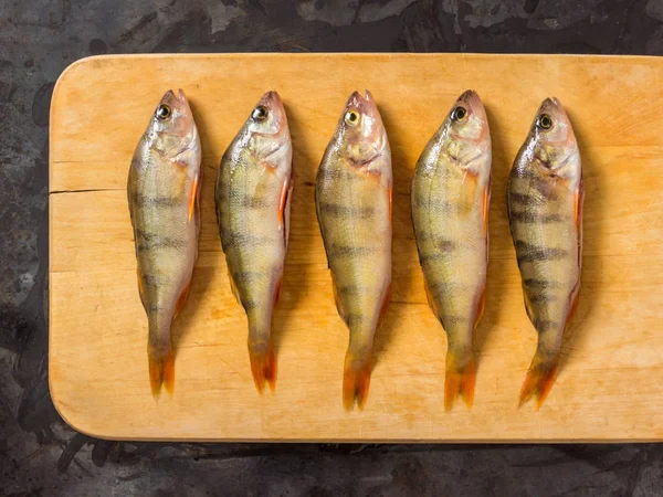 Fresh fish. Fresh river fish perch. On a yellow wooden background. Top view