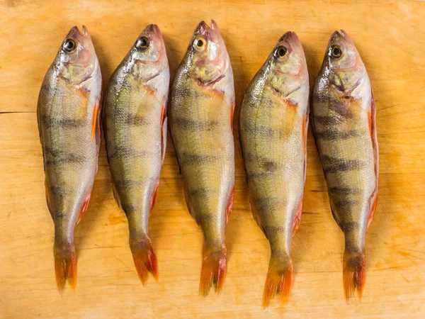 Fresh fish. Fresh river fish perch. On a yellow wooden background. Top view