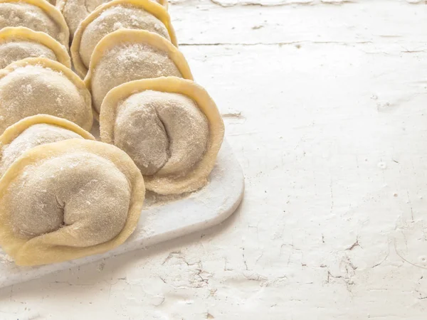 Geleneksel Rus el yapımı hamur tatlısı tahtada donmuş. Rus pelmeni. Ravioli