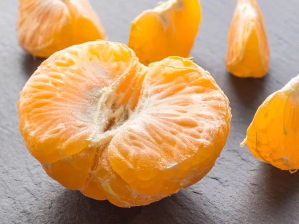 Tangerines slices on black background. Orange mandarin