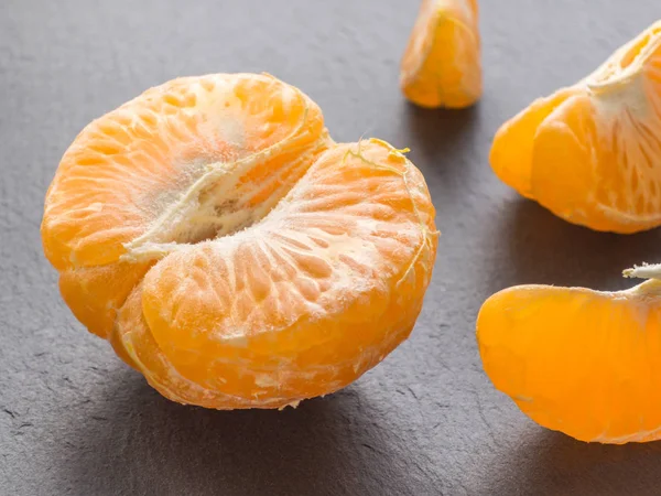 Tangerines slices on black background. Orange mandarin