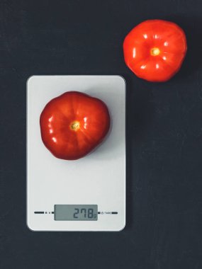 Diyet kavramı, doğru beslenme, sağlıklı yemek. Mutfak terazisi domatese. Ürünler ağırlığında. Üstten görünüm