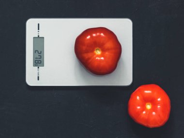 Diyet kavramı, doğru beslenme, sağlıklı yemek. Mutfak terazisi domatese. Ürünler ağırlığında. Üstten görünüm