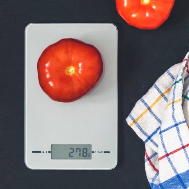 Diyet kavramı, doğru beslenme, sağlıklı yemek. Mutfak terazisi domatese. Ürünler ağırlığında. Üstten görünüm