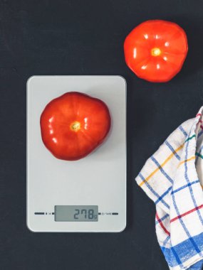 Diyet kavramı, doğru beslenme, sağlıklı yemek. Mutfak terazisi domatese. Ürünler ağırlığında. Üstten görünüm