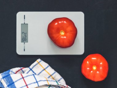 Diyet kavramı, doğru beslenme, sağlıklı yemek. Mutfak terazisi domatese. Ürünler ağırlığında. Üstten görünüm