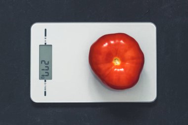 Diyet kavramı, doğru beslenme, sağlıklı yemek. Mutfak terazisi domatese. Ürünler ağırlığında. Üstten görünüm