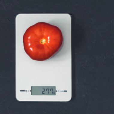 Diyet kavramı, doğru beslenme, sağlıklı yemek. Mutfak terazisi domatese. Ürünler ağırlığında. Üstten görünüm