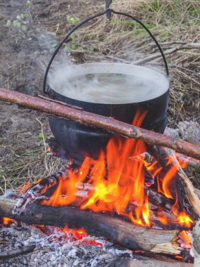 Turist pot ateşe asılı. Balık çorbası
