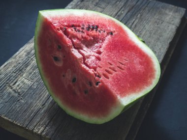 Taze kırmızı olgun karpuz ahşap bir arka plan üzerine dilimlenmiş
