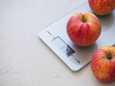 Kırmızı elma mutfak üzerinde beyaz arka plan üzerinde ölçekler. Ürün tartma