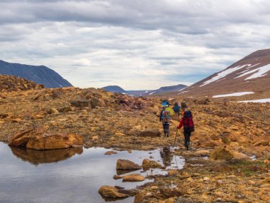 Turistler dağlardan aşağı in. Güzel dağ manzarası, panorama. Karlı tepe. Kutup Urallar dağlar. Yamal
