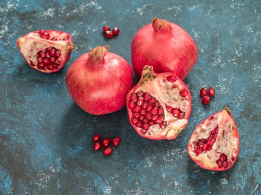 Rustik koyu mavi arka plan üzerinde taze Olgun kırmızı nar meyve. Sağlıklı gıda, portre, düz yatıyordu, en iyi görünümü