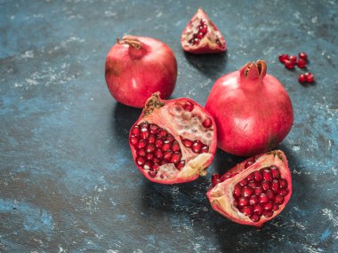 Rustik koyu mavi arka plan üzerinde taze Olgun kırmızı nar meyve. Sağlıklı gıda, portre, düz yatıyordu, en iyi görünümü