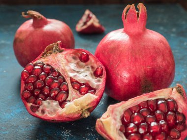 Rustik koyu mavi arka plan üzerinde taze Olgun kırmızı nar meyve. Sağlıklı gıda, portre, düz yatıyordu, en iyi görünümü