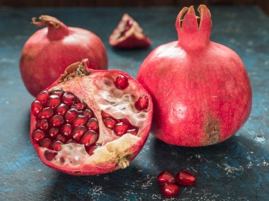 Rustik koyu mavi arka plan üzerinde taze Olgun kırmızı nar meyve. Sağlıklı gıda, portre, düz yatıyordu, en iyi görünümü