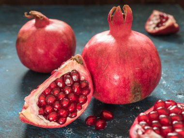 Rustik koyu mavi arka plan üzerinde taze Olgun kırmızı nar meyve. Sağlıklı gıda, portre, düz yatıyordu, en iyi görünümü