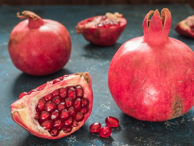 Rustik koyu mavi arka plan üzerinde taze Olgun kırmızı nar meyve. Sağlıklı gıda, portre, düz yatıyordu, en iyi görünümü