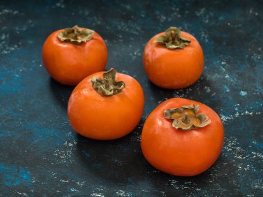 Olgun turuncu incir Trabzon hurması meyve mavi grunge arka plan üzerinde. Düz yatıyordu. Üstten görünüm. Kopya alanı