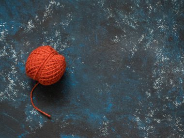 Turuncu yün iplik dolaştırmak koyu mavi grunge arka plan üzerinde. Düz yatıyordu, en iyi görünümü