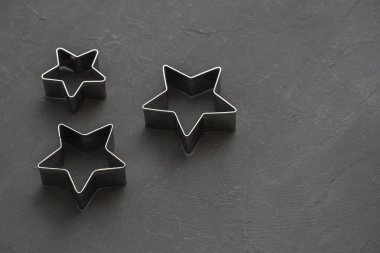 Metal yıldız şenlikli siyah arka plan üzerine. Fırın kalıpları. Çerez kesici. Düz yatıyordu, en iyi görünümü