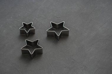 Metal yıldız şenlikli siyah arka plan üzerine. Fırın kalıpları. Çerez kesici. Düz yatıyordu, en iyi görünümü