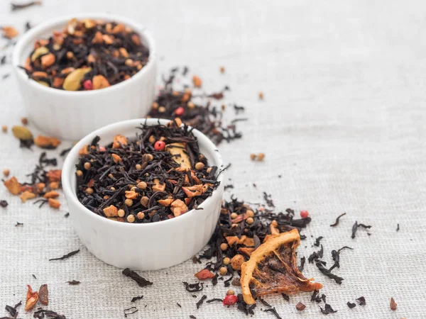 Dry leaves of black fruit tea with cinnamon, apple, orange, coriander, cardamom, cloves and red pepper