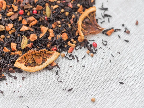 Dry leaves of black fruit tea with cinnamon, apple, orange, coriander, cardamom, cloves and red pepper