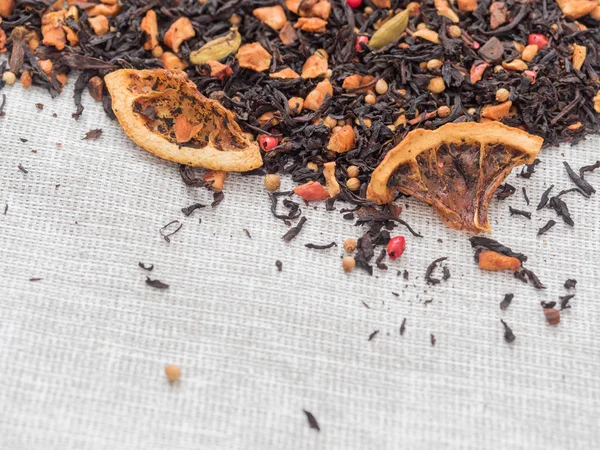 Dry leaves of black fruit tea with cinnamon, apple, orange, coriander, cardamom, cloves and red pepper