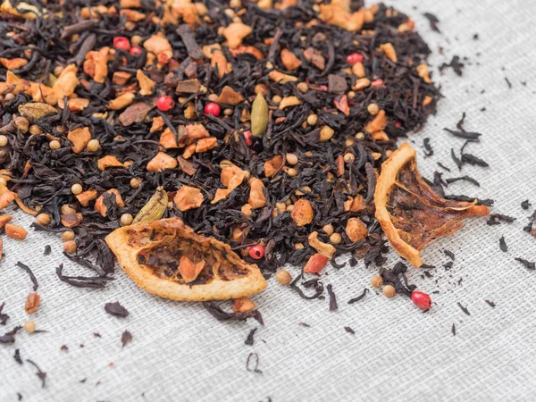 Dry leaves of black fruit tea with cinnamon, apple, orange, coriander, cardamom, cloves and red pepper