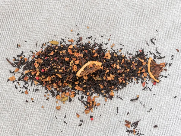 Dry leaves of black fruit tea with cinnamon, apple, orange, coriander, cardamom, cloves and red pepper