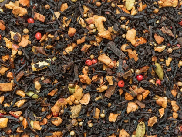 Dry leaves of black fruit tea with cinnamon, apple, orange, coriander, cardamom, cloves and red pepper