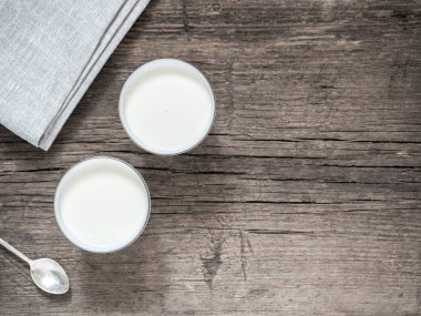 Sağlıklı kahvaltı. Yoğurt ahşap arka plan üzerinde beyaz gözlük. Uzay kopyalayın, yatıyordu, en iyi görünüm düz