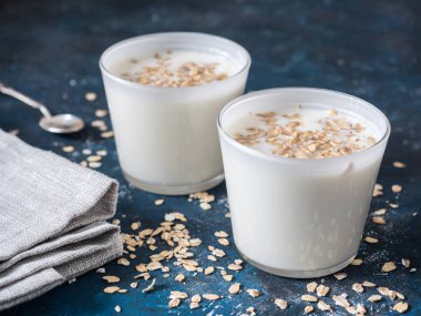 Sağlıklı kahvaltı. Yoğurtlu yulaf gevreği mavi bir arka plan üzerinde beyaz gözlük.