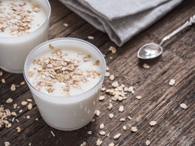 Sağlıklı kahvaltı. Yoğurtlu yulaf gevreği ahşap bir masa üzerinde beyaz gözlük