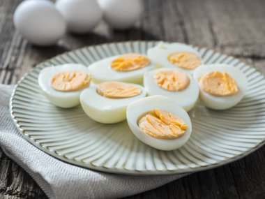 Haşlanmış tavuk yumurtası gri bir plaka üzerinde. Ahşap arka plan. Paskalya kavramı