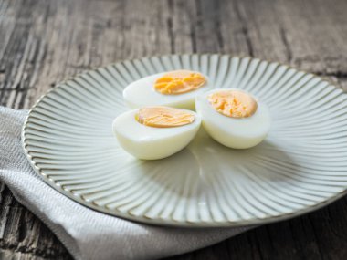 Haşlanmış tavuk yumurtası gri bir plaka üzerinde. Ahşap arka plan. Paskalya kavramı