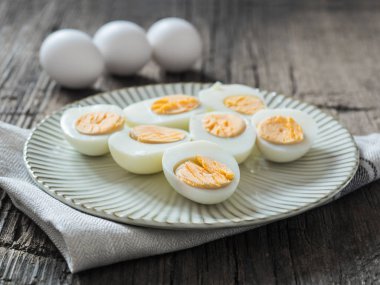 Haşlanmış tavuk yumurtası gri bir plaka üzerinde. Ahşap arka plan. Paskalya kavramı