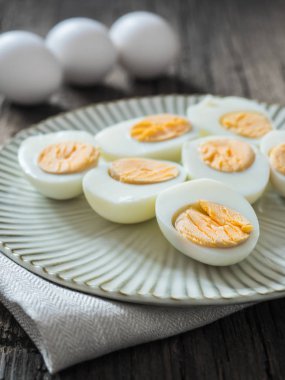 Haşlanmış tavuk yumurtası gri bir plaka üzerinde. Ahşap arka plan. Paskalya kavramı