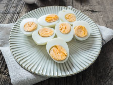 Haşlanmış tavuk yumurtası gri bir plaka üzerinde. Ahşap arka plan. Paskalya kavramı