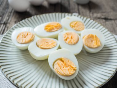 Haşlanmış tavuk yumurtası gri bir plaka üzerinde. Ahşap arka plan. Paskalya kavramı