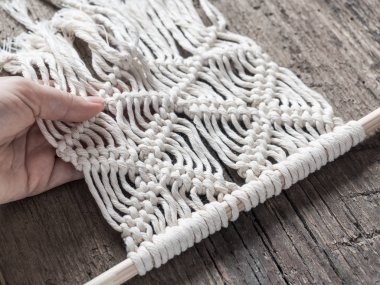 Makrome. Kız makrome örgüleri. Beyaz iplik, el, ahşap arka plan, portre